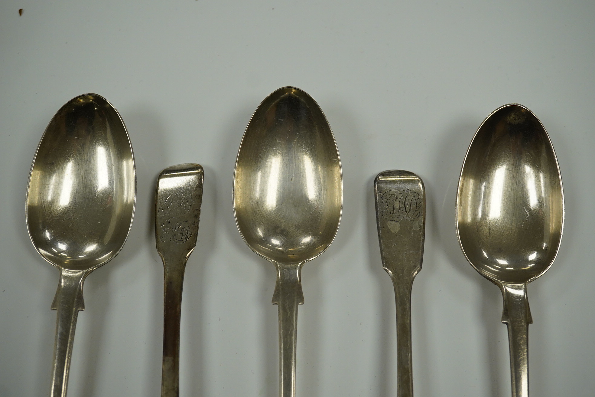 A harlequin set of twelve William IV/Victorian silver fiddle pattern dessert spoons, various date and makers, 17.7oz. Condition - poor to fair